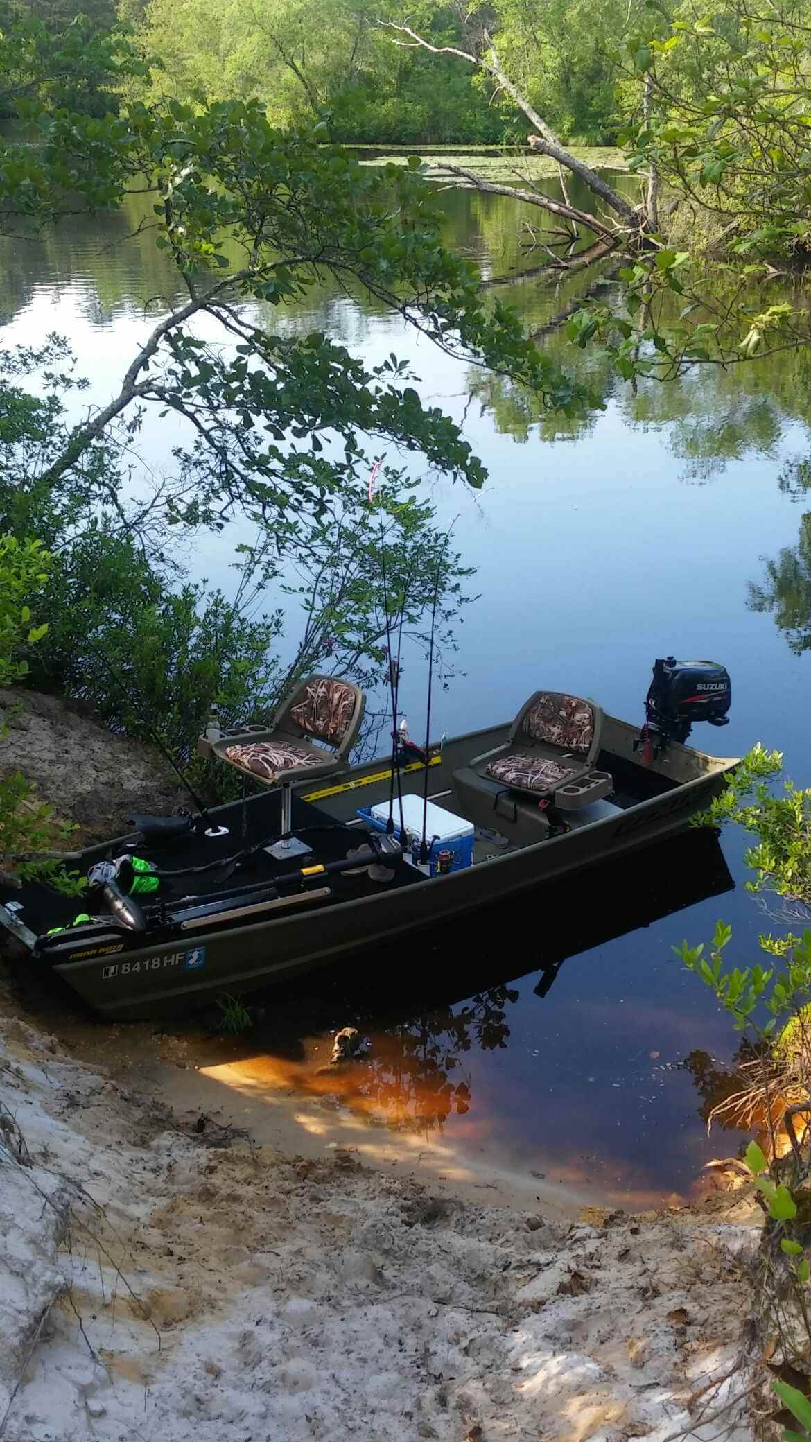 Three anglers in kayaks paddling across a deep blue Irish lake.